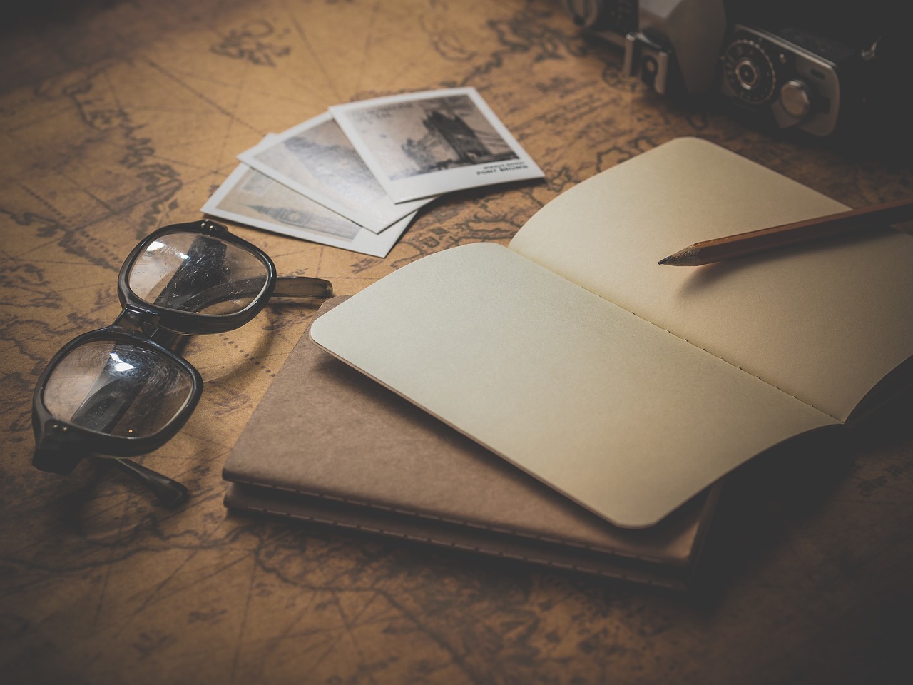 glasses, notepad, pen and photo's on a table